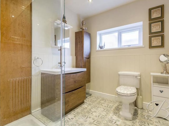 This modern shower room comprises a delightful three-piece suite. There is a walk-in shower cubicle, a low-flush WC, hand wash basin with storage, downlights and an opaque window to the side of the property.