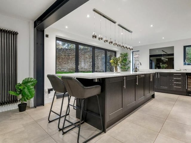 Above the central island is feature pendant lighting, which is available to buyers by separate negotiation. There is also LED over and under-lighting, a full-height radiator and a wall-mounted, tinted mirror splashback, which gives a feeling of even more space.