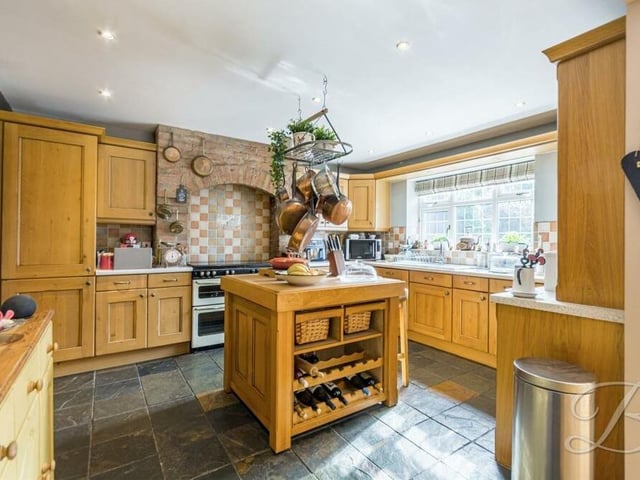 The kitchen also boasts a Rangemaster cooker with tiling and brick surround, an integrated fridge freezer, ceramic sink with mixer tap above, dishwasher, downlights and a tiled floor. The window faces the back garden.