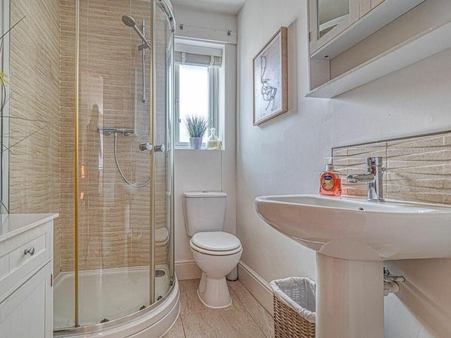 The en suite sower room to bedroom number one consists of a shower cubicle, pedestal sink, low-level toilet and tiled floor