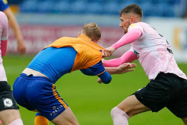 Harry Charsley has his shirt almost pulled off at home to Barrow.