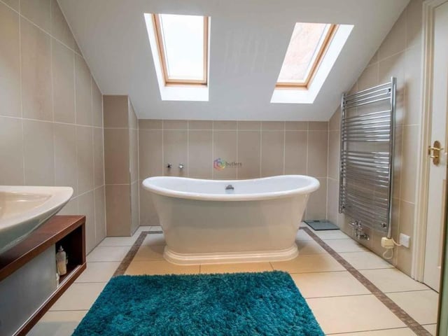 The en suite bathroom to the main bedroom has the wow factor. It features a roll-top, free-standing bath beneath two Velux windows, allowing you to watch the stars while you soak and relax!