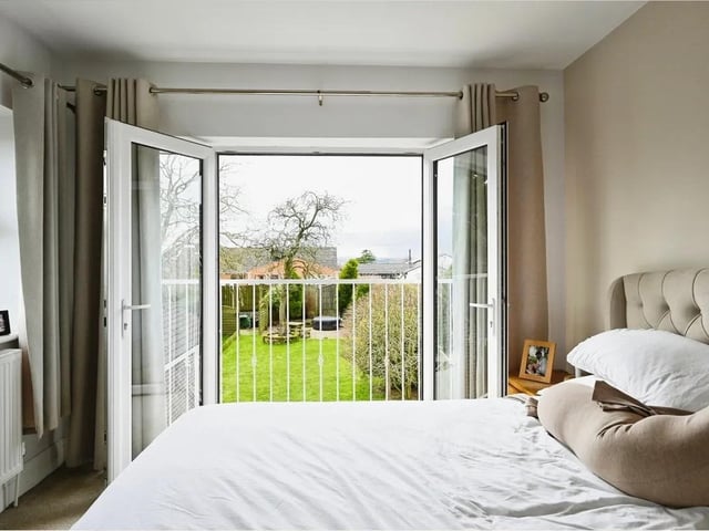The master bedroom is a serene haven with a stunning garden view