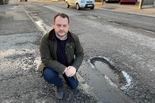 Coun Jason Zadrozny, leader of Ashfield District Council, by one of the many potholes on High Pavement in Sutton.