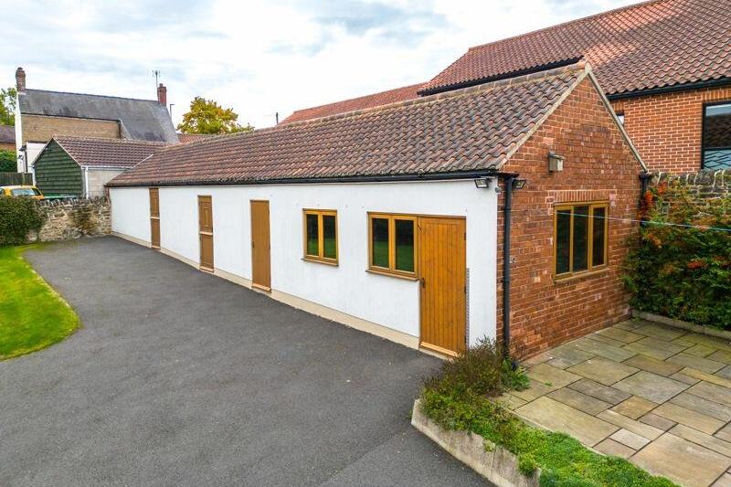 Outbuildings on the plot include this former stable block, which has been refurbished and now contains four versatile rooms that could make short-term holiday lets.