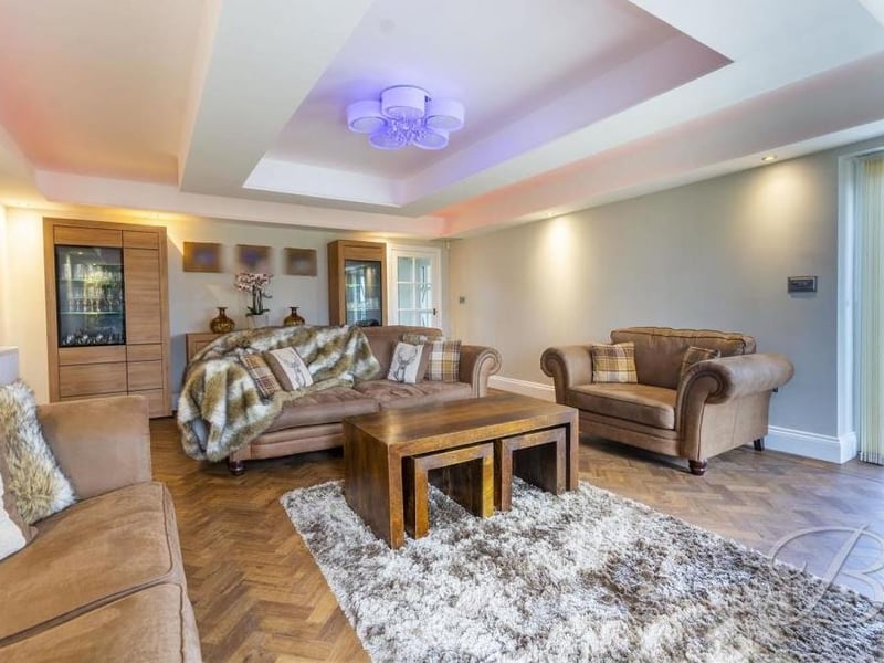 A second shot of the spacious main living room, which benefits from delightful herringbone flooring.