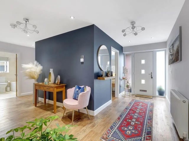 The entrance hall provides a welcoming approach to the property and features two full-height UPVC double-glazed obscure windows to the front elevation, allowing natural light into the space while maintaining privacy. The hall benefits from attractive wood flooring, a built-in large storage cupboard with double doors providing useful storage, and a vertical radiator with a mirrored insert.