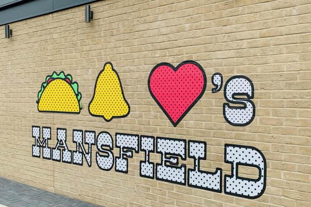 'Taco Bell loves Mansfield' is painted on the wall of the drive-thru.