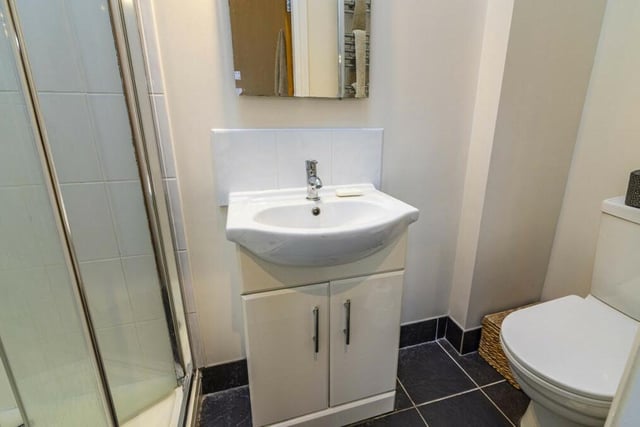 The en suite shower room to the master bedroom is fitted with a shower cubicle, hand wash basin with storage beneath, and low-flush WC.