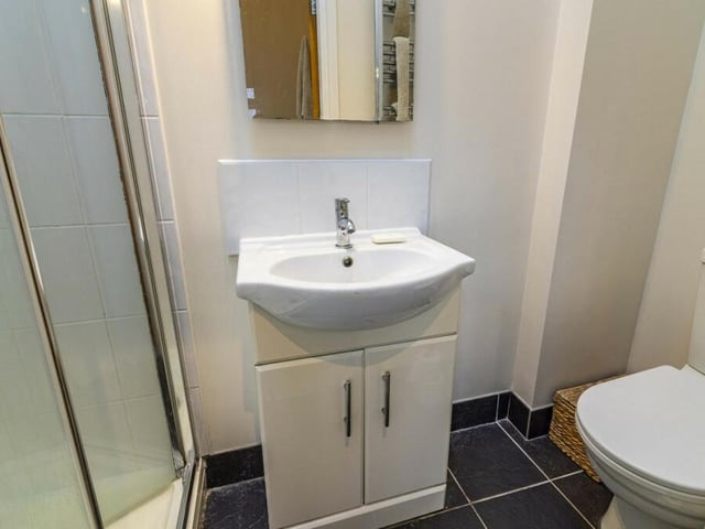 The en suite shower room to the master bedroom is fitted with a shower cubicle, hand wash basin with storage beneath, and low-flush WC.