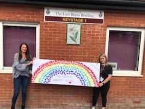 Staff members with a poster that pupils designed.