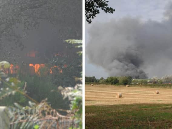 Firefighters tackle a blaze and work to prevent spreading into nearby woodland