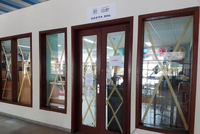 Windows are taped up and stores emptied to prepare for the storm.