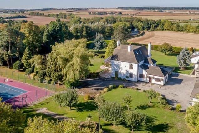 This six bedroom detached home sits on a two acre plot and features a leisure suite and tennis court.