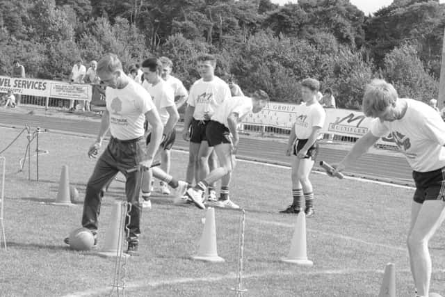 1990: These young men are testing out their football skills in this relay race at the Mansfield Show. Are you on this picture?