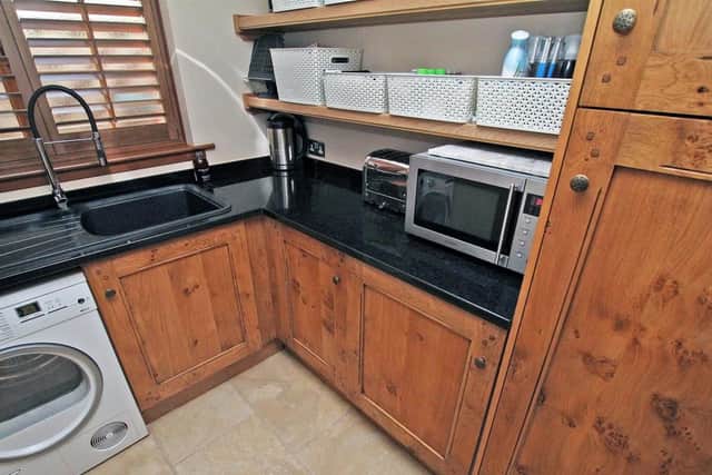 The stylish utility room has plumbing a washing machine as well as more fitted units.