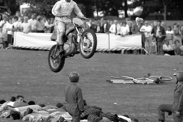 1989: This daredevil stunt rider attempts to jump over a line of volunteers. A fabulous bygone snap taken at the Mansfield Carnival. Did you volunteer?