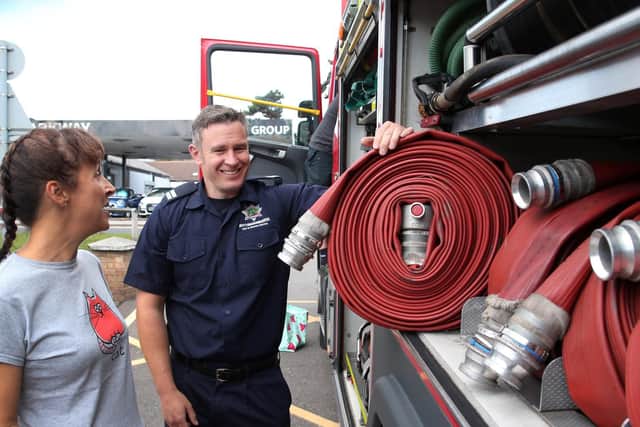 Crew manager Carey Thomas explains to Ann-Marie Argile about the hose reels carried on the fire engine.