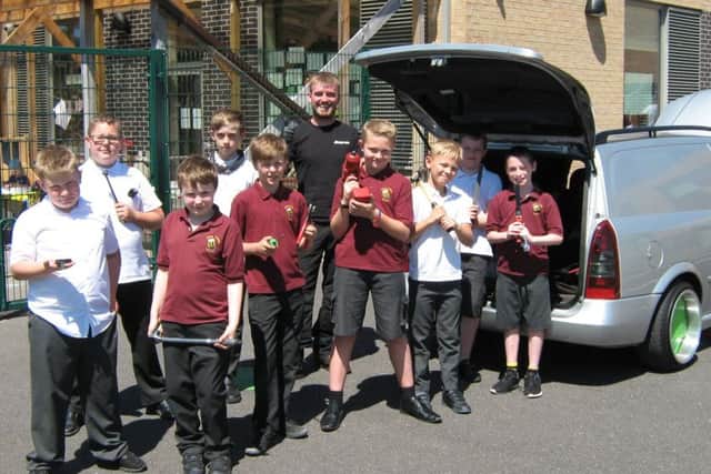 Garage owner Liam Hanrahan shows these youngsters what life is like as a mechanic.