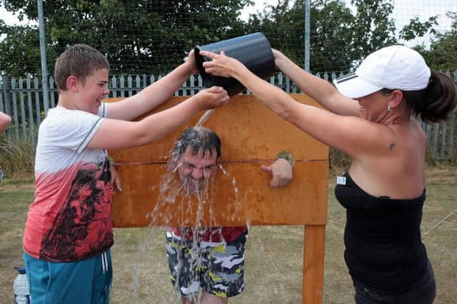 Winston White gets a cooling off from Gabe White and Jannine Bexon at Renfest, United Kingdom, 14th July 2018. Photo by Glenn Ashley.