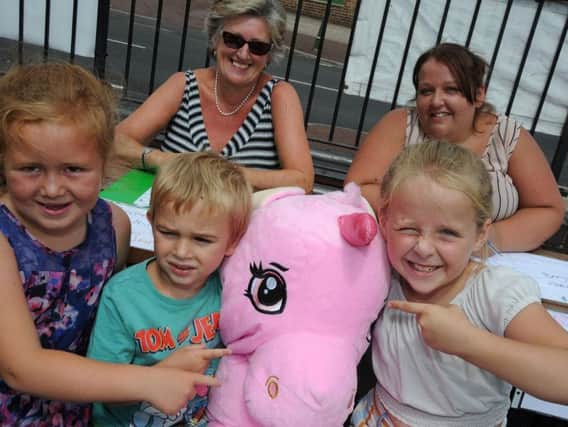 Daisy Taylor, 7, Tyler Lillian, 4 and 8 year old Madelane Barker try and guess the name of the giant unicorn on one of the stalls at the Emma Brown fundraiser with stall holders Chris Hunt and Karen Barker.
