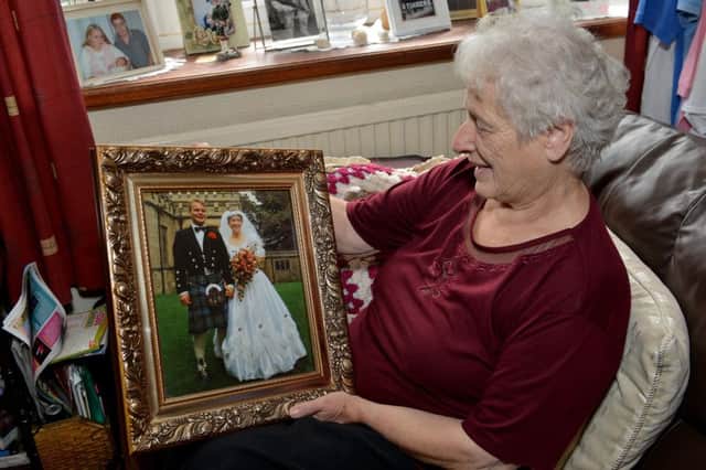 Joan pictured with a picture of her daughter who died from leukemia 25 years ago