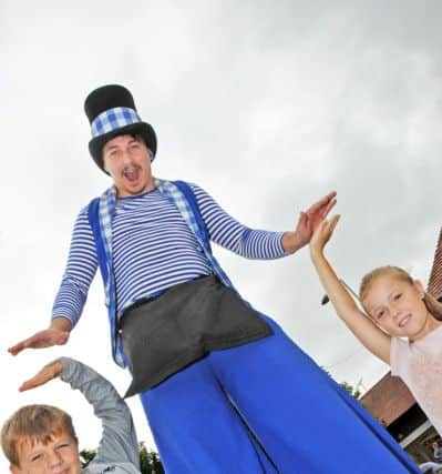 Kirkby Plaza Fun Day.Mason Richards, 10 and his 9 year old sister, Poppy, from Kirkby, give high fives to Joker Entertainment's Blake Murray.