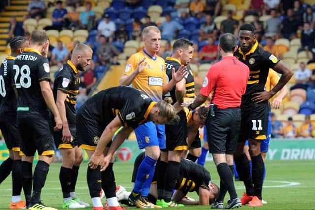 Mansfield Town v Newport County.Neal Bishop pleads his case but picks up a yellow card.