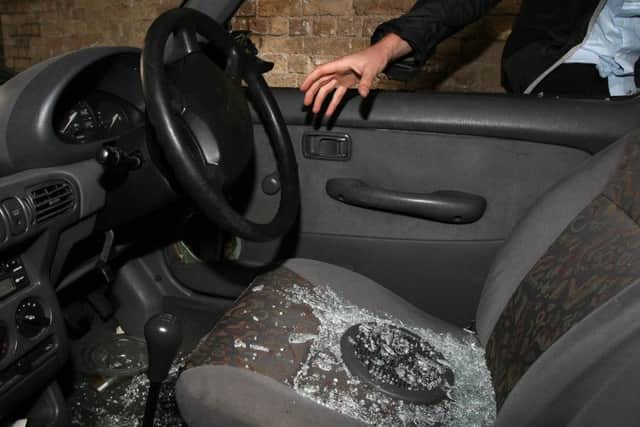 Stock picture posed by model: A hand reaches into a car through a broken window. See PA story.
