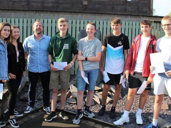 Students celebrate their exam results with maths teacher Mr Lyndon