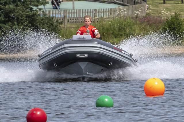 Ten-year-old Edward Ryder, of Mansfield, at the helm of his powerboat. (PHOTO BY: David Eberlin)