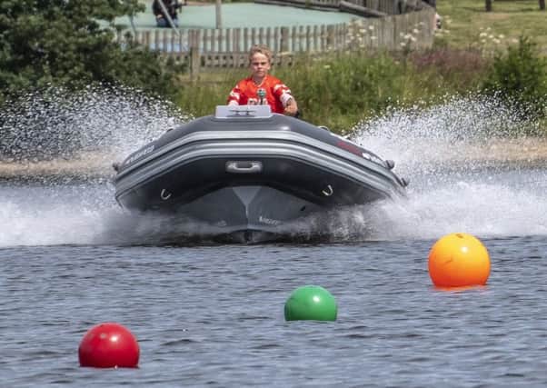 Ten-year-old Edward Ryder, of Mansfield, at the helm of his powerboat. (PHOTO BY: David Eberlin)