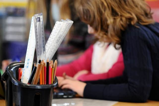 A generic stock photo shows Primary School children at work in a classroom.