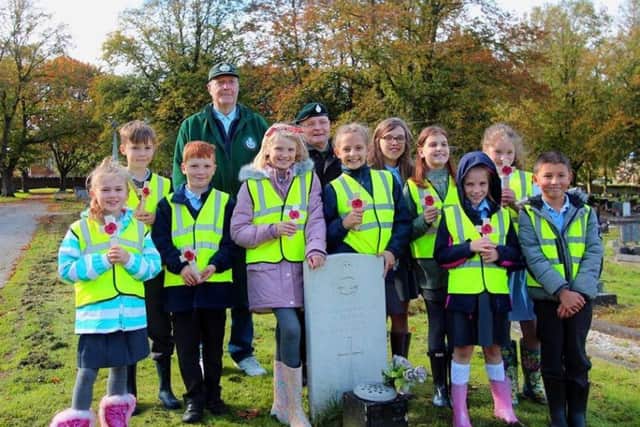 Roy with the students at the cemetery.  Picture by DARRON ELLIS