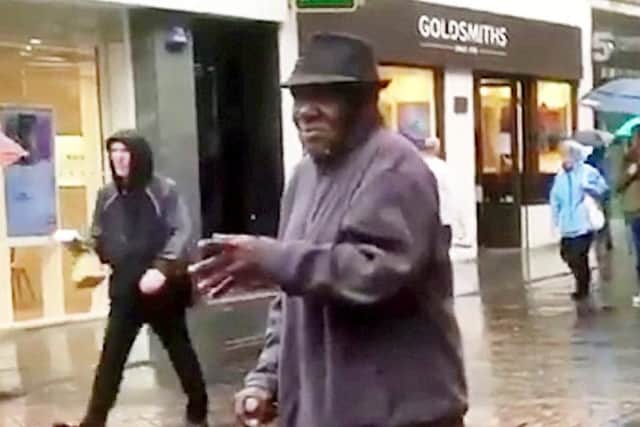 The elderly man was walking past the saxophonist when he stopped and started dancing