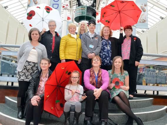 People involved in making the rememberella installation gather at Idlewells shopping centre in Sutton in Ashfield.