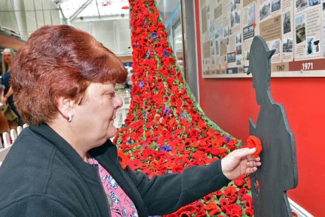 Mandy Bainbridge putting the finishing touch to a Poppy installation at Idlewells shopping centre in Sutton.
