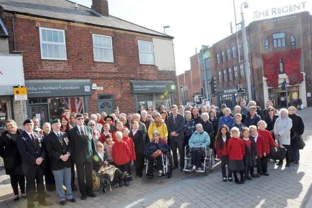Residents join Rachel Sellars, second left, manager of The Regent, Ashfield District Council staff and officials and Royal British Legion members at the unveiling of the cascade of poppies in Kirkby on Friday.