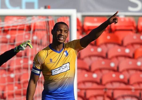 Mansfield skipper Krystian Pearce directs his players at Swindon.