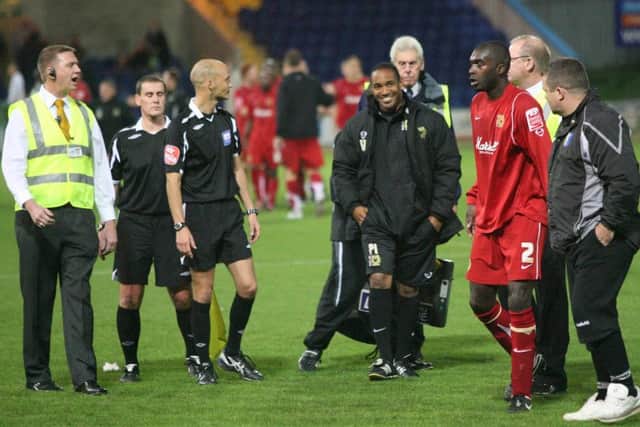 Stags assistant boss Paul Holland and Dons manager Paul Ince exchange thoughts on the referee's performance.