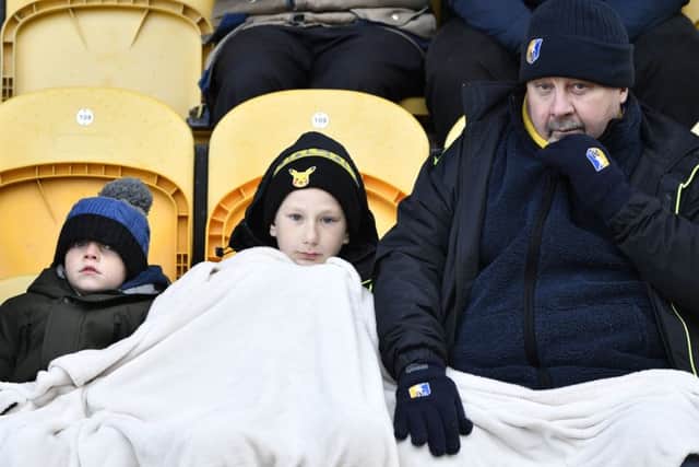 Mansfield Town fans try to keep warm during the game: Picture by Steve Flynn/AHPIX.com, Football: Skybet League 2  match Mansfield Town -V- MK Dons at One Call Stadium, Mansfield, Nottinghamshire, England on copyright picture Howard Roe 07973 739229