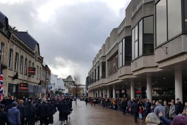 Hundreds gather to watch the parade pass West Gate.