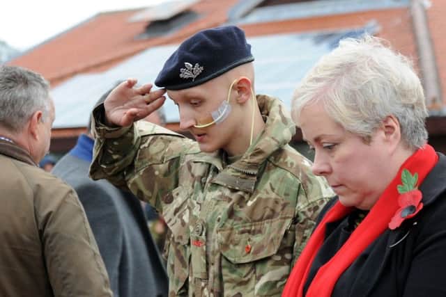 Mansfield Remembrance wreath laying. Cadet Jacob Fradgley from the Army Cadet Force salutes after laying his wreath alongside Coun. Sonya Ward.