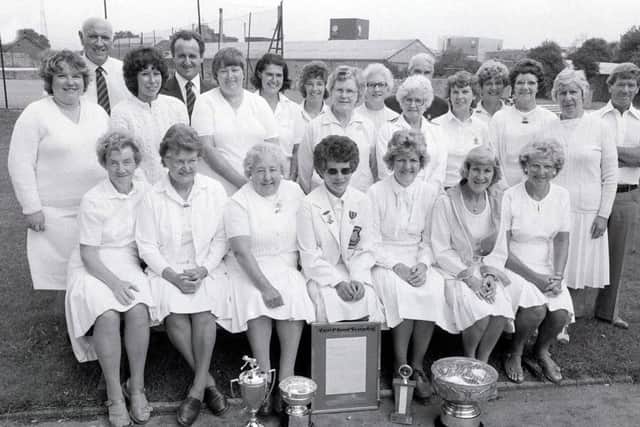 1982: Mansfield ladies bowling club finals. This glamourous bunch of ladies.....- oops and gentlemen - look like they won, judging by all the trophies laid before them.