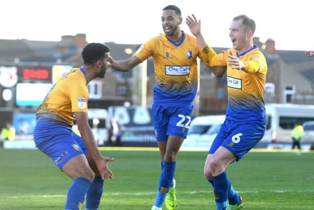 Mansfield's Neal Bishop celebrates his goal with his teammates Jacob Mellis (l) and CJ Hamilton at Grimsby.