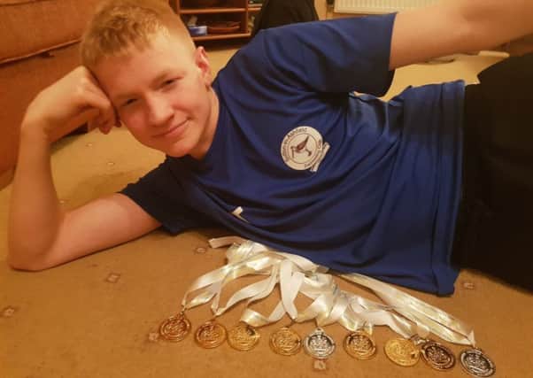 Sutton swimmer Tom Trueman with his haul of nine medals from the county championships.