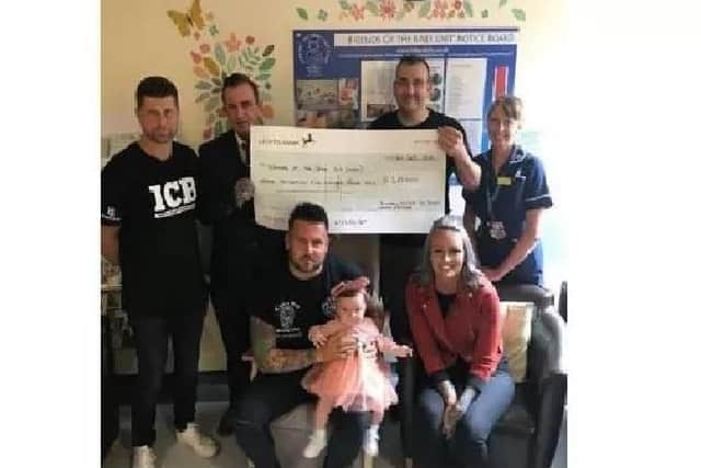 Darren Lalor and baby Sienna present a cheque to Derby Hospital's Neo Natal Intensive Care Unit.