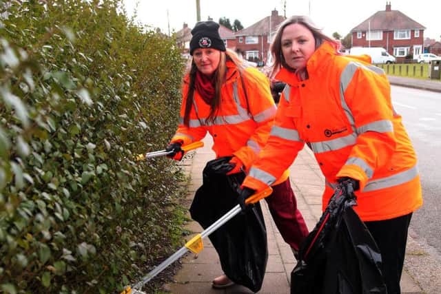 Carol Cooper-Smith and Sam Dennis pick the litter from the hedge on the Twitchell.