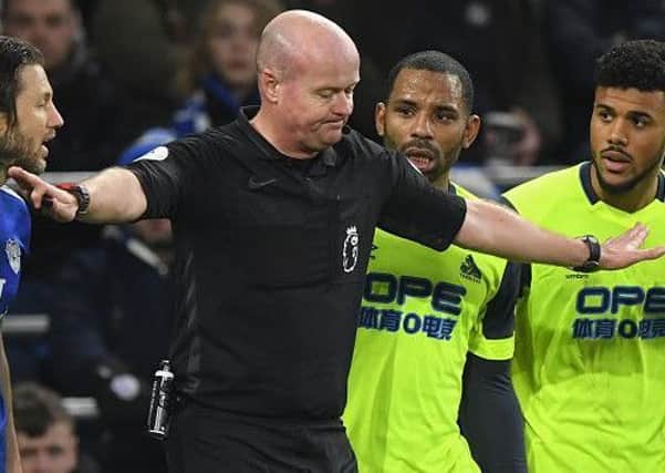 CARDIFF, WALES - JANUARY 12:  Referee Lee Mason changes his mind over awarding Huddersfield a penalty as the Huddersfield players Jason Puncheon and Elias Kachunga react to the news during the Premier League match between Cardiff City and Huddersfield Town at Cardiff City Stadium on January 12, 2019 in Cardiff, United Kingdom.  (Photo by Stu Forster/Getty Images)