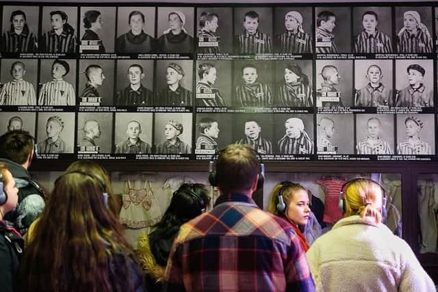 Photographs of children from the camp line the walls, along with clothes that were found at the former concentration camp.
